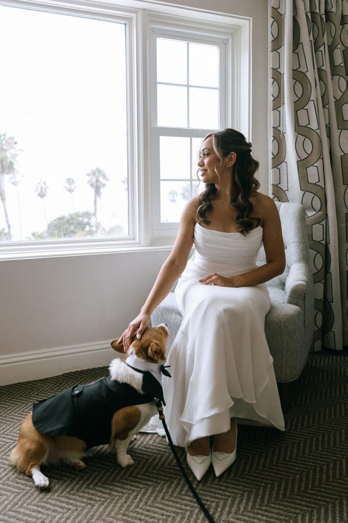 A bride poses with her dog before her wedding at la valencia in la jolla